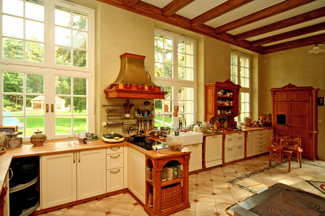 Drewniana dwukolorowa biało-brązowa kuchnia na wymiar z drewnianymi blatami i duże białe drewniane okna.