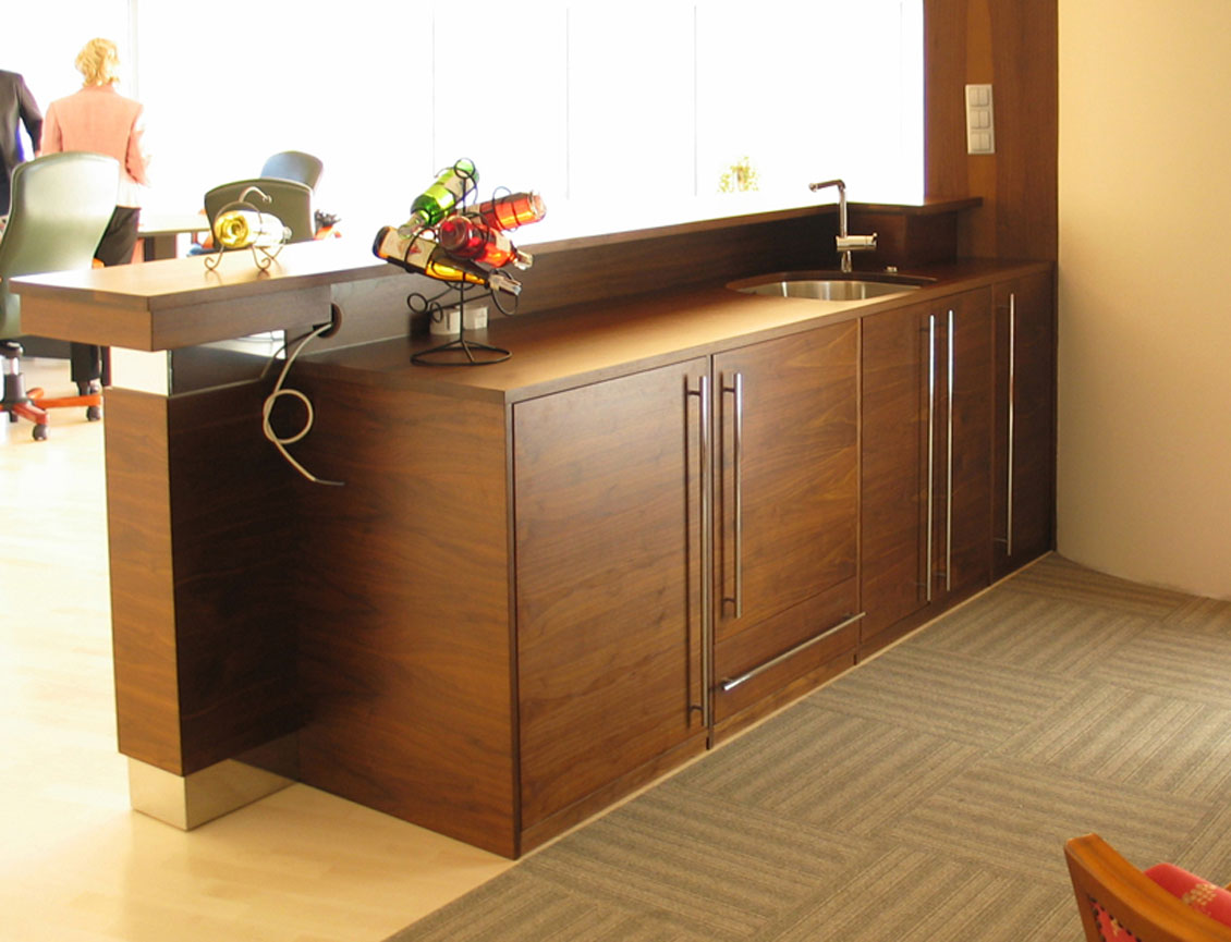 Drewniany blat oddzielający kuchnię w biurze od reszty pomieszczenia.