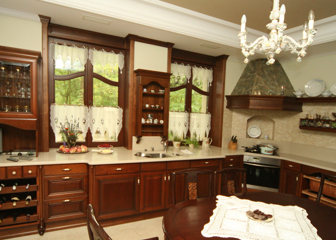 Drewniane okna na wymiar w pięknej drewnianej kuchni, okna i meble kuchenne są w kolorze ciemnobrązowym.