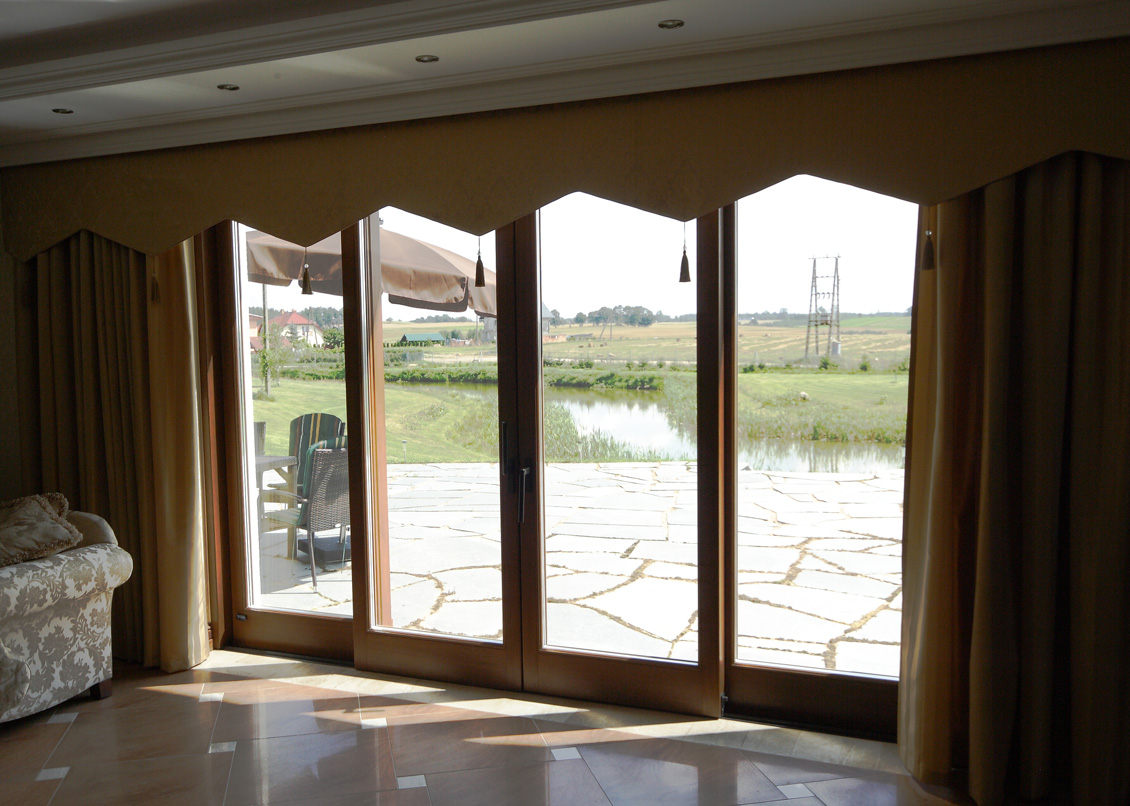 Duże powierzchniowo okna z drewna będące właściwie drzwiami wyjściowymi na taras.