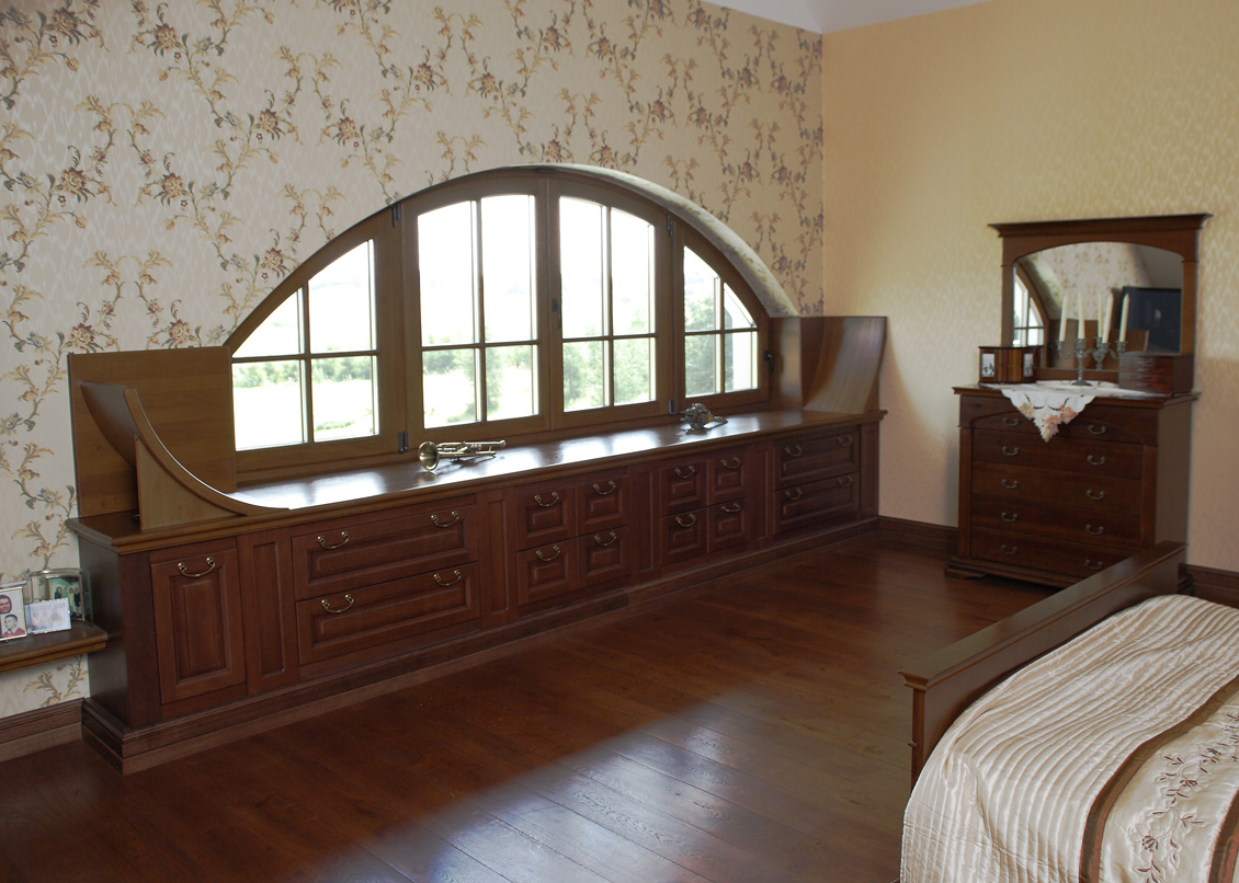 Niskie drewniane okno na wymiar, widok z sypialni, wraz z oknem w pokoju są niskie drewniane meble na wymiar i łóżko.